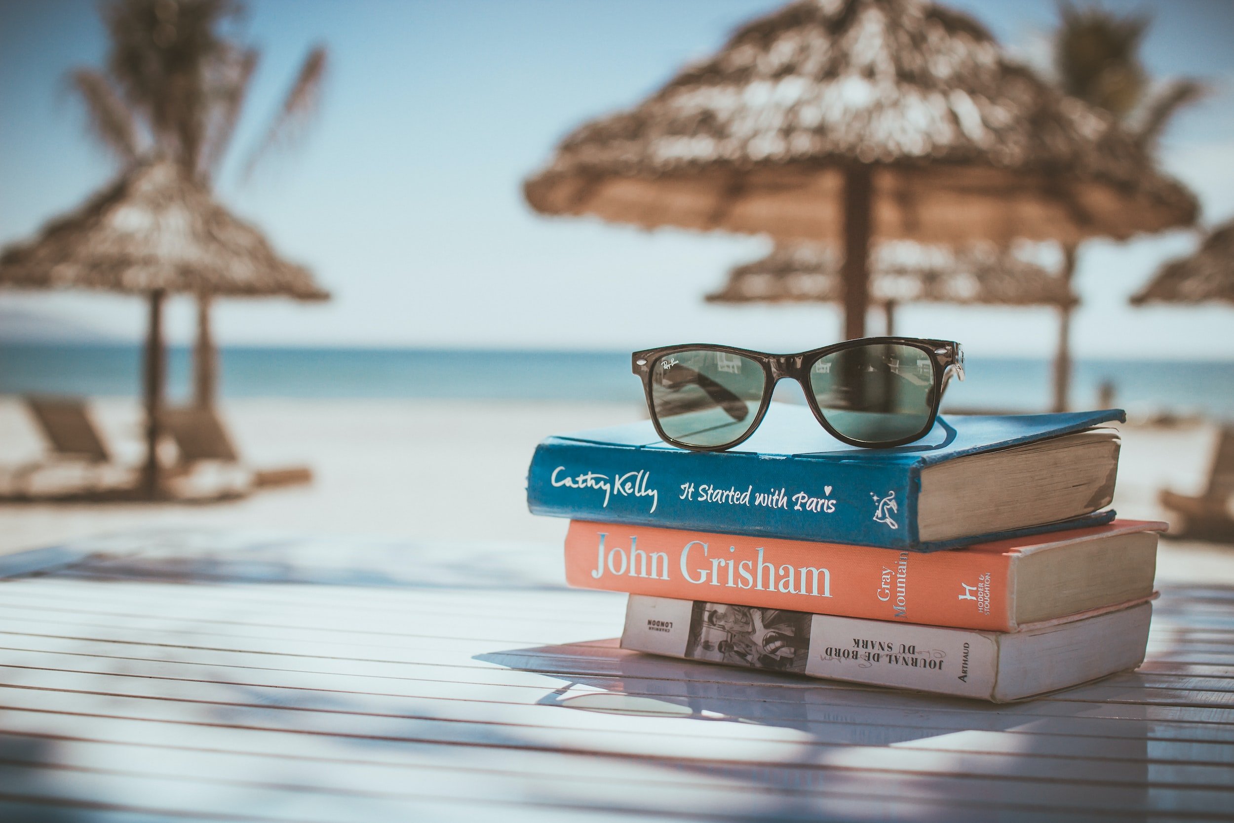 Picture of books on a table at the beach.